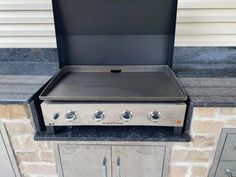 an outdoor grill with two burners on the top and one open door to the outside