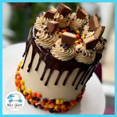 a cake with chocolate frosting and candy toppings sitting on top of a white plate