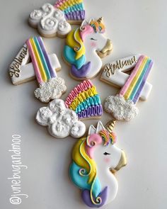 decorated cookies with unicorns and rainbows are on a white counter top, next to the words hello kitty