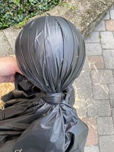 a person is holding a black trash bag