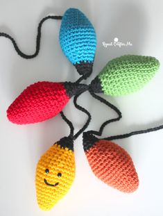 four crocheted lights with smiling faces on them