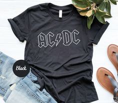 Rock'n Roll Shirt, ACDC Shirt, Rock Band Shirt, Rock Music Shirt, Rock Shirt Gift, ACDC Gift, Thunderstruck, Back In Black, Gift for Rocker Please check Shirt and Sweatshirt sizes carefully.. Hi! Welcome to YiYuTee store, I'm so happy to see you here. My store's main goal is to make you happy. Sweatshirt Details: This soft sweatshirt has a loose fit for a comfortable feel. With durable print, it will be a walking billboard for years to come. 50% Cotton Made by specially spinned fibers that make very strong and smooth fabric, perfect for printing. 50% Polyester Polyester fibers are extremely strong, resistant to most chemicals, stretching and shrinking. Viscose adds amazing draping and softness to the shirt. Machine wash: warm (max 40C or 105F); Non-chlorine: bleach as needed; Tumble dry: m Rock And Roll Shirt Ideas, Black Band Logo Merch Shirt, Black Band Logo Shirt, Rock Style Letter Print Tops For Concerts, Black Edgy Tops For Music Festivals, Unisex Black Rock T-shirt, Black Rock And Roll Tops For Streetwear, Rocker Tops With Letter Print For Concert, Black Shirt For Music Festival Fan Merchandise