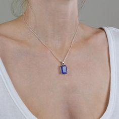 A delicate balance of rich blue and violet, this gem has fine crystal inclusions and an exquisite luster. Wearing this deep blue-hued beauty of a faceted tanzanite necklace will add an elegant touch to any outfit. Known as the ‘stone of magic’ it brings its wearer the confidence to turn ideas into reality. Bringing the “will” to start and enhancing from beginning to end. This stone is also great for Communication and Protection. Stone Origin: ﻿Tanzania Measures Approximately: 16 x 12 mm Material Blue Birthstone Rectangular Pendant Necklace, Blue Birthstone Necklace With Rectangular Pendant, Elegant Blue Tanzanite Gemstones, Blue Amethyst Pendant Necklaces, Blue Amethyst Pendant Necklace, Blue Rectangular Pendant Birthstone Jewelry, Elegant Blue Sterling Silver Crystal Necklaces, Elegant Blue Sterling Silver Crystal Necklace, Elegant Blue Crystal Sterling Silver Necklace