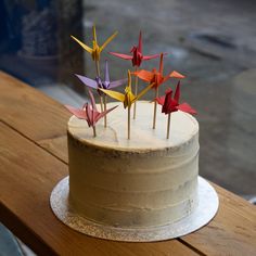 there is a cake decorated with paper cranes