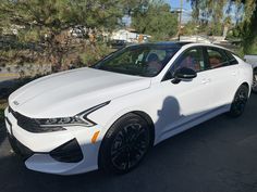 a white car is parked on the street