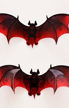 two red and black bats with horns on white background, one is facing the opposite direction