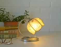 a lamp that is on top of a table next to some books and eyeglasses