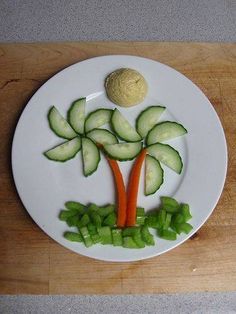 a white plate topped with cucumbers and carrots on top of a wooden table