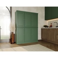 a kitchen with green cupboards and white counter tops in the center of the room