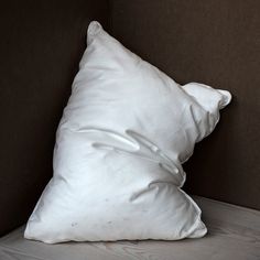 a white pillow sitting on top of a bed