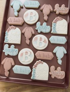 decorated cookies in the shape of baby's names on a tray