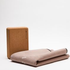 two pieces of cloth sitting next to each other on a white surface with a cardboard box in the background