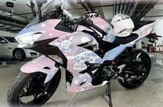 a pink and black motorcycle parked in a garage