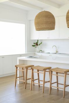 three stools sit in front of the kitchen counter