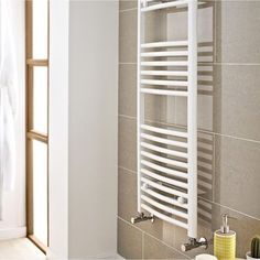 a white towel rack in a bathroom next to a window