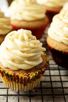 cupcakes with white frosting on a cooling rack