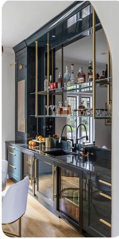 a kitchen with black cabinets and gold trim