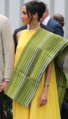 the couple is dressed in bright yellow and green attire, while holding hands with each other