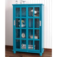 a blue cabinet with glass doors on top