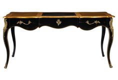 an antique black and gold desk with drawers