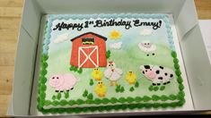 a birthday cake decorated with farm animals and sheep in a box on a wooden table