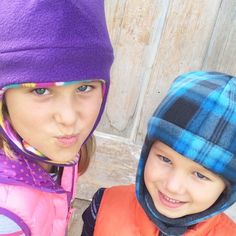 two young children wearing winter clothing and hats