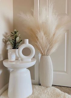 a white vase with some plants in it