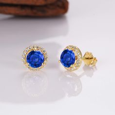 Add a little luxury, class, and sophistication to your look with our breathtaking Jia sapphire earrings. Made from our stunning gold on sterling silver materials, each iconic earring features a whopping 0.75-carat center sapphire. We’ve also added numerous stunning CZ crystals around the outer rim of the earrings for an unrivaled shine. ✦ DETAILS ✦ ✧ Handcrafted ✧ .75 Carat center stone ✧ Sapphire and cz crystals ✧ 8mm (about 6/8 inch round) ✧ Sterling Silver 925 or 14K Rose Gold Vermeil or 14K Sapphire Birthstone Earrings For Formal Occasions, Classic Blue Halo Earrings, Formal Sapphire Earrings With Halo, Luxury Sapphire Earrings With Halo Setting, Fine Jewelry Sapphire Earrings With Halo Design, Sapphire Earrings With Halo Design Fine Jewelry, Sapphire Earrings With Halo Design, Sapphire Round Cut Earrings With Halo Design, Classic Sapphire Birthstone Earrings