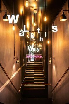 stairs leading up to the top of a building with lights hanging from it's sides