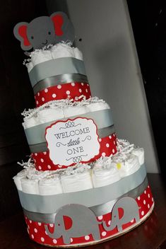 a three tiered diaper cake with elephants on it