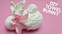 a white teddy bear with a pink bow on it's head and the words diy towel bunny above it