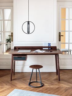 a desk with a lamp hanging over it