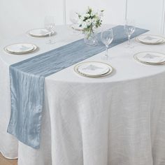 the table is set with white and blue linens