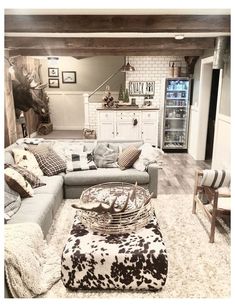 a living room filled with furniture and a cow print rug on top of a wooden floor