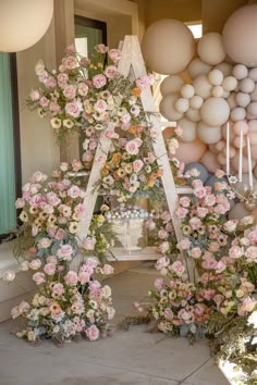 a bunch of flowers that are in front of some balloons on the wall and floor