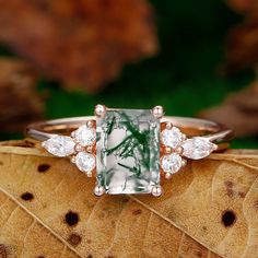 a green and white ring sitting on top of a leaf