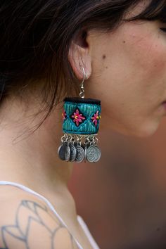 a close up of a person wearing some kind of earring with flowers on it