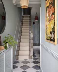 an entry way with stairs and paintings on the walls