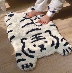 a child's feet on a rug that looks like a tiger