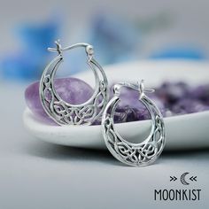 These Celtic Hoop Earrings feature a beautiful endless knot filigree design. The hoops are finished with 18 gauge sterling silver ear wires with a latch closure. One of the oldest styles of earring, hoops have been worn by both men and women since the Bronze Ages. Materials - Sterling Silver Cast Component, sterling silver ear post, sterling silver push earring back Dimensions - Length (with ear wire): 25 mm, Hoop Width: 10 mm, Post Length: 13 mm Includes One Year Warranty Endless Knot, Earring Hoops, Filigree Design, Bronze Age, Earring Backs, Ear Wire, Ear Wires, Old Fashioned, Knot