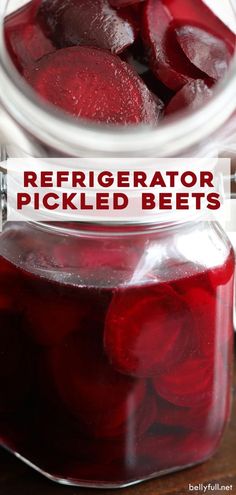 a jar filled with pickled beets sitting on top of a wooden table next to another jar