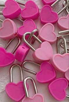 pink and silver heart shaped paper clips on a white tablecloth covered with plastic material