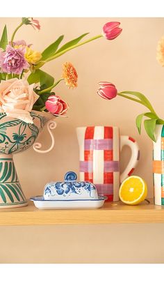 colorful flowers and vases sit on a shelf