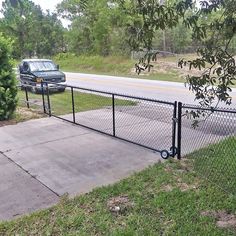 a car parked behind a fence next to a road