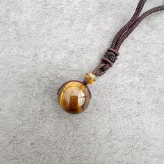 Discover the beauty, symbolism, and versatility of the Stone Sphere Rope Necklace as it becomes a unique expression of your style and connection to the energy of natural gemstones. Spheres are symbolic of completeness, unity, and the cyclical nature of life. The stone sphere on this necklace serves as a reminder of the interconnectedness of all things and the continuous flow of energy. The rope necklace is suitable for both everyday wear and special occasions. Its adjustable design and natural e Spiritual Agate Round Pendant Crystal Necklace, Spiritual Agate Crystal Necklace With Round Pendant, Obsidian Amulet Necklace As Gift, Obsidian Amulet Necklace For Gift, Spiritual Round Agate Crystal Necklace, Obsidian Gemstone Beads Necklace As Gift, Spiritual Agate Crystal Necklace, Obsidian Gemstone Beads Necklace For Gift, Obsidian Necklace With Gemstone Beads As Gift