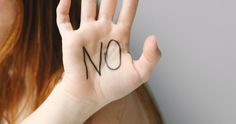 a woman is holding her hand up with the word no written on it in front of her