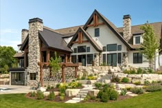 a large house with stone steps leading up to it's front entrance and landscaping