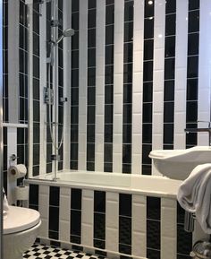 a bathroom with black and white tiles on the walls