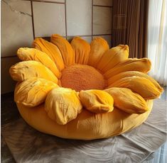 a large yellow flower sitting on top of a bed