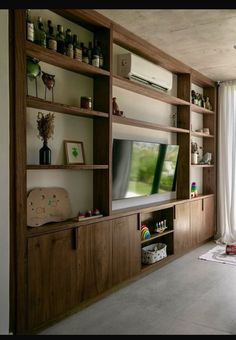 a living room filled with furniture and a flat screen tv mounted on a wooden wall